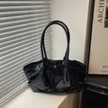 Minimalist black glossy leather tote bag with gold buckle and shoulder straps - Black