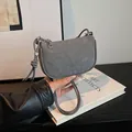 Bolso de hombro media luna en ante gris con correa anudada y detalles metálicos plateados - Gris