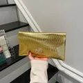 Elegante pochette a busta dorata con trama metallica pieghettata e chiusura a cuore - Oro