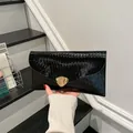 Elegante pochette a busta nera con finitura lucida e fibbia in metallo dorato lucido - Nero