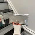 Pochette a busta argento metallizzato con trama a onde e fibbia dorata geometrica - Argento