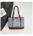 Blue denim tote bag with brown leather handles and metal logo nameplate detail - Blue Without Charm