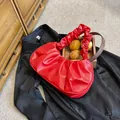 Detalle del bolso de nube roja plisado con un elegante asa redonda de madera - Rojo