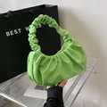 Primer plano detallado del bolso nube verde brillante con textura fruncida y asa plisada - Verde claro