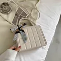 Elegant cream quilted handbag with silk scarf handle detail on a lifestyle background - Off White