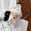 White canvas sling bag featuring a 3D plush brown bear ornament and black strap - White