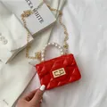 Mini red quilted pearl handbag with golden chain strap and polished metallic clasp - Red