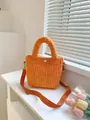 Detail of bright orange corduroy bucket bag with wide top handle and matching nylon strap - Orange