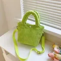 Detail view of lime green corduroy handbag with textured fabric and white snap closure - Light Green
