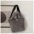 Close-up of dark grey corduroy bucket bag texture with white snap button and strap - Gray