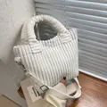 Chic white corduroy bucket bag with handle and detachable strap on a wooden desk - White