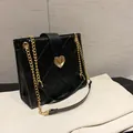 Klassische schwarze Stepptasche mit goldenem Herzschloss und Ketten-Schultergurt - Schwarz