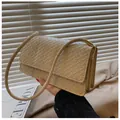 Detailansicht der beigefarbenen geflochtenen Ledertasche mit goldenen Metallschnallen - Khaki