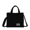 Minimalist black canvas tote bag with white woven label and top handles for women - Black