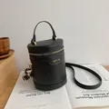 Μαύρη κυλινδρική τσάντα bucket με υφή κροκόδειλου και χρυσές μεταλλικές λεπτομέρειες - Μαύρο