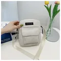 Detail view of cream corduroy crossbody bag with front pocket and adjustable strap - Off White