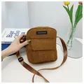 Detailed view of brown corduroy shoulder bag showing fabric texture and brand label - Brown
