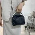 Minimalist black square handbag with light grey handle and matte faux leather finish - Black
