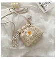 Detail der handgewebten Stroh-Eimertasche mit kleiner Margerite und Kordelzugverschluss - Weiß