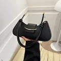 Minimalist black geometric shoulder bag with gold crescent buckle and knotted strap - Black