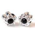 Close-up of silver flower stud earrings with black zircon center in layered petal design - Black