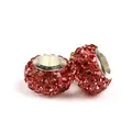 Macro shot of two red rhinestone charm beads with silver metal cores for DIY bracelets - Pink