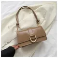 Close-up of khaki leather baguette bag featuring a large gold D-shaped buckle and knotted strap - Khaki