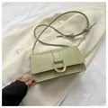 Detail of light green leather baguette bag with golden U-shaped buckle and knot strap - Green