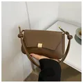 Brown leather baguette bag with a gold square metal buckle and decorative knotted strap - Brown