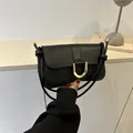 Schicke schwarze Unterarmtasche mit goldener Hufeisenschnalle und Knotendetail am Gurt - Schwarz