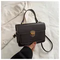 Detail of vintage dark brown leather bag with golden shield lock and FANYISSA logo - Coffee