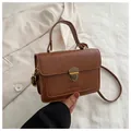 Nahaufnahme der braunen Vintage-Tasche mit Metallschloss und geprägtem Markenschriftzug - Hellbraun