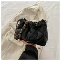 Elegante borsa a secchiello nera trapuntata con catena dorata e ciondolo a sfera - Nero