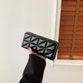 Lange schwarze Lackleder-Geldbörse mit Reißverschluss und 3D-geometrischem Steppmuster - Schwarz