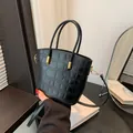 Sac seau noir style français avec motif pierre, texture crocodile et détails dorés chics - Noir