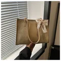 Beigefarbene Stroh-Tote-Bag mit braunen Ledergriffen und rosa Blumen-Spitzenschleife - Khaki