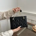 Elegant black quilted underarm bag with gold chain handles and vertical stitch design - Black
