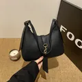 Elegante borsa hobo in pelle martellata nera con fibbia a ferro di cavallo dorata - Nero