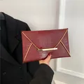 Elegant burgundy crocodile pattern envelope clutch bag with gold metal trim and leather texture - Red
