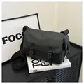 Solid black minimalist messenger bag with matte finish and dual buckle flap closure - Black