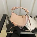Pink crescent handbag with twisted handle and golden hardware in modern style - With Pendant / Pink