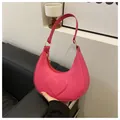 Detail of pink crescent underarm bag featuring a 3D embossed heart and gold metal rings - Rose Pink
