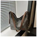 Dettaglio della borsa hobo in tela grigio-verde con tasche esterne e targhetta in pelle - Nero
