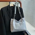 Hellblaue Shopper-Tasche aus Leder mit Buchstaben-Prägung und stilvollem Kettengurt - Blau