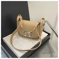 Detail of beige saddle bag featuring a decorative silver metal bow buckle and fine texture - Khaki