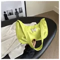 Close-up of bright lime green underarm bag with silver butterfly metal ornament - Green