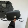 Schwarze Umhängetasche aus Leder mit gewelltem Boden und silberner Gliederkette - Schwarz