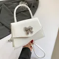 Minimalistische weiße Lackledertasche mit silberner Schmetterlingsschnalle und Schultergurt - Weiß
