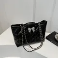 Schwarze gesteppte Ketten-Schultertasche mit eleganter silberner Metall-Schleifenschnalle - Schwarz