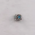 Vintage silver rose charm bead with sea blue crystal center on white plush backdrop - Lake Blue